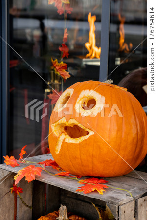 Exterior Beautiful atmospheric halloween carved pumpkins decorated on porch. Autumn leaves and fall flowers celebration holiday Thanksgiving October season Exterior Beautiful atmospheric halloween carved pumpkins decorated on porch. Autumn leaves and fall flowers celebration holiday Thanksgiving October season 126754614