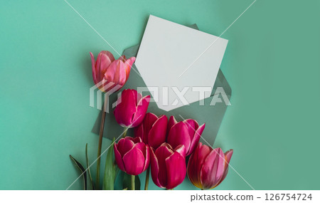 Empty white envelope copy space for your text or design with beautiful pink tulip bouquet on green background. Template mock up for holiday spring greeting card. Top view Flat lay blank paper Feminine Empty white envelope copy space for your text or design with beautiful pink tulip bouquet on green background. Template mock up for holiday spring greeting card. Top view Flat lay blank paper Feminine 126754724