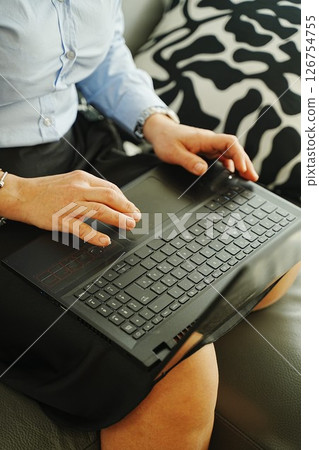 Businesswoman Typing on Laptop While Sitting on Couch 126754755