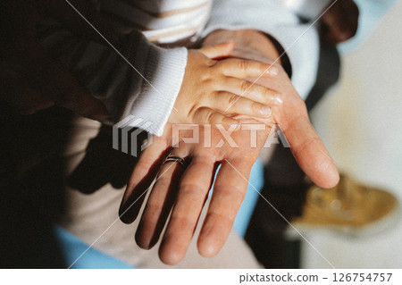 Child's Hand Resting on Parent's Hand in Tender Moment 126754757