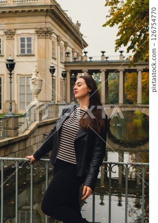 Tourist attraction woman travel enjoying nature sightseeing Baths classicist Palace on the Isle in Lazienki Park touristic place in Warsaw. Lazienki Royal Baths Park, Baroque columns Warsaw Poland Tourist attraction woman travel enjoying nature sightseeing Baths classicist Palace on the Isle in Lazienki Park touristic place in Warsaw. Lazienki Royal Baths Park, Baroque columns Warsaw Poland 126754770