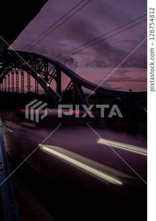 Defocused Lights of cars at night in Krakow bridge. Street line lights. Night highway city. Long exposure photograph night road. Colored bands of red light trails on the road. Background wallpaper  126754812