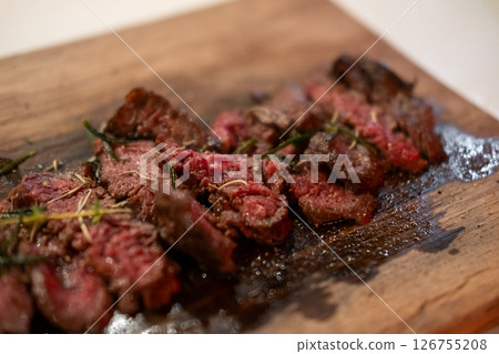 Medium rare sliced fried meat on wooden plate 126755208