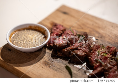 Medium rare sliced fried meat on wooden plate 126755209