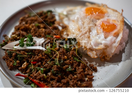 Stir-fried Basil with Minced Beef served on plate with fried egg. A popular Thai dish known as Pad Kra Pao 126755210