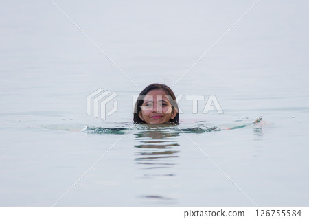 young asian woman enjoying swimming and smiling in shallow water of sea 126755584