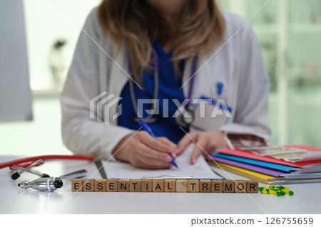 A Health Professional Conducting an Examination of Essential Tremor Patient Case Notes and Records 126755659