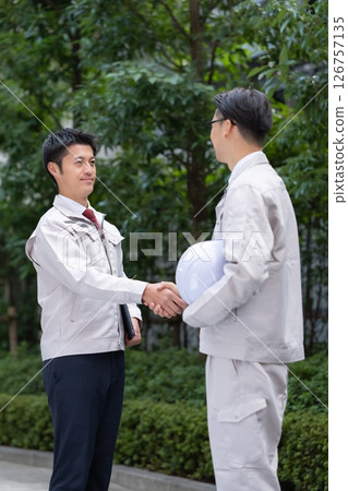 Men work clothes shaking hands 126757135