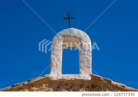 Christian cross on whitewashed arch at village church 126757330