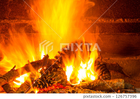 burning firewood in chimney with pine cones burning firewood in chimney with pine cones 126757396