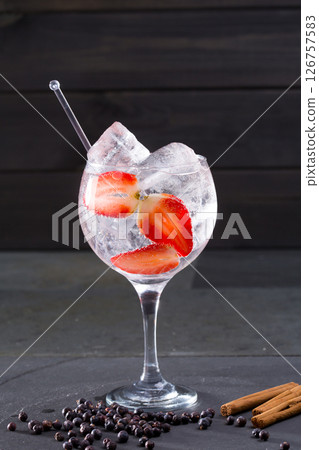 Gin tonic cocktail with strawberries cinnamon and juniper Gin tonic cocktail with strawberries cinnamon and juniper 126757583