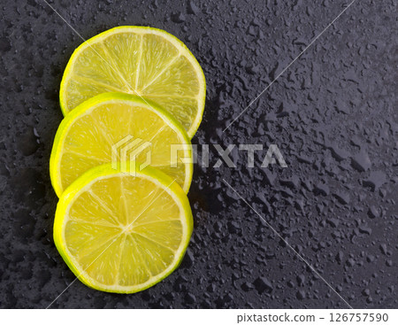 Fresh lima slices with water drops on black 126757590