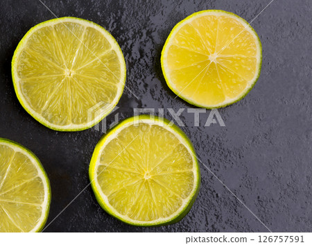 Fresh lima slices with water drops on black 126757591