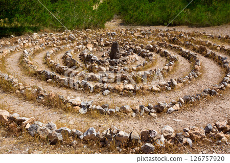 Atlantis spiral sign in Ibiza with stones on soil 126757920