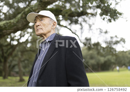 Elderly asian man listening to music in park 126758492