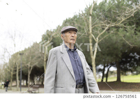 Elderly asian man listening music walking in park 126758561
