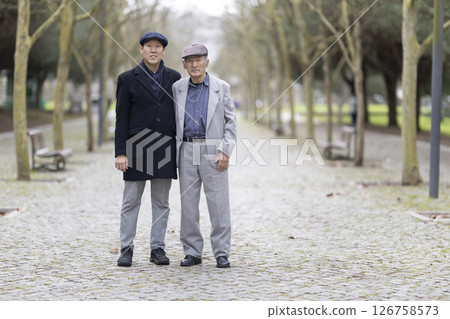 Asian father and son posing together in park 126758573