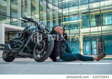 Handsome motorcyclist on his moto riding in the city. High quality photo 126758641