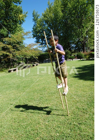 Children playing on stilts 126758673