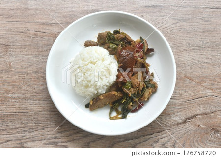 spicy stir fried slice sweet roasted duck meat with chili and basil on rice in plate 126758720