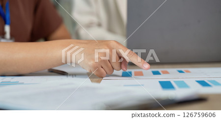Data Analysis and Strategy. Professional pointing at financial graphs during a team meeting. Data Analysis and Strategy. Professional pointing at financial graphs during a team meeting. 126759606