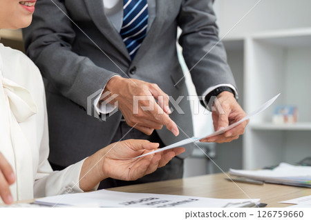 Teamwork in Financial Review. Business professionals analyzing financial documents together. Teamwork in Financial Review. Business professionals analyzing financial documents together. 126759660