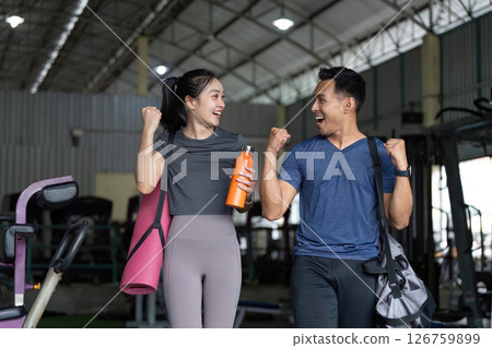 Wellness and Friendship. Two friends celebrating fitness achievements at the gym. 126759899