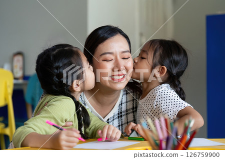 Back to School. Affectionate moment between a teacher and her students during art class. 126759900