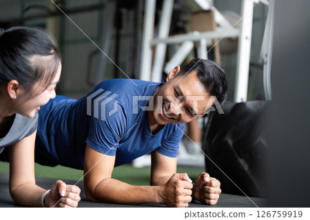 Wellness and Friendship. Friends sharing laughter during a fitness session at the gym. Wellness and Friendship. Friends sharing laughter during a fitness session at the gym. 126759919