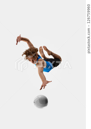 Sporty male athlete, volleyball player dives with focused look and open hand reaching for ball against white studio background. Concept of sport events 126759960