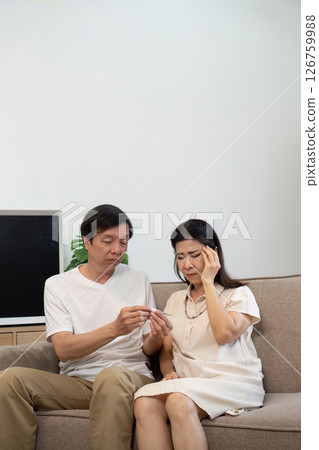 Wellness and Care. Elderly couple discussing health while sitting on a sofa. Wellness and Care. Elderly couple discussing health while sitting on a sofa. 126759988