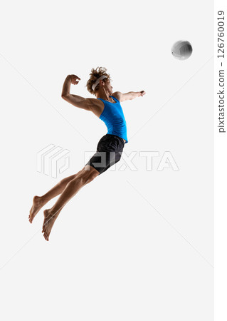 Volleyball player jumps to hit the ball with power and full focus during attack showing athletic form against white studio background. Concept of championship Volleyball player jumps to hit the ball with power and full focus during attack showing athletic form against white studio background. Concept of championship 126760019