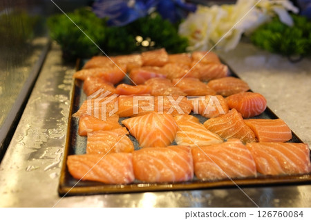 Traditional Norwegian fresh salmon in slices with lemon slices served as close-up on a Nordic design tray with text space Traditional Norwegian fresh salmon in slices with lemon slices served as close-up on a Nordic design tray with text space 126760084