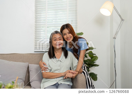 Wellness and Togetherness. Mother and daughter sharing a warm embrace on the couch. 126760088