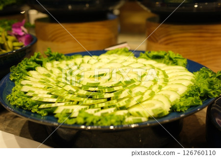 Cucumber platter Buffet meal consisting of vegetables and cucumber slices and chili sauce served in plastic wrap at an event 126760110