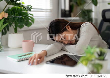 Mental Health and Emotional Resilience. Young woman resting at her desk, overwhelmed by work stress. 126760320