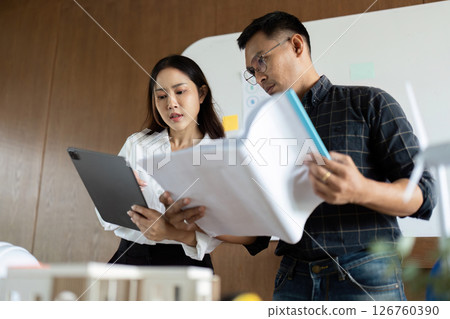 Sustainability and Engineering. Team of engineers discussing eco-friendly project plans in an office. 126760390