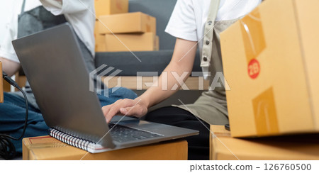 Close-up of Laptop and Packages in E-commerce Workspace Close-up of Laptop and Packages in E-commerce Workspace 126760500