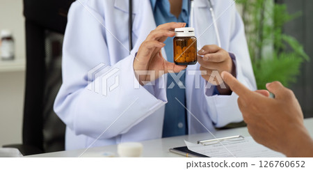 Health and Wellness. Doctor discussing medication with patient in a clinical setting. Health and Wellness. Doctor discussing medication with patient in a clinical setting. 126760652