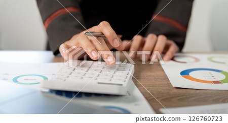 Close-Up of Business Professional Using Calculator and Analyzing Financial Data. Close-Up of Business Professional Using Calculator and Analyzing Financial Data. 126760723