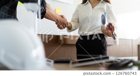 Sustainability in Engineering. Engineers shaking hands over eco-friendly project agreement. 126760743