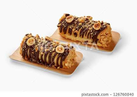Two hazelnut and chocolate covered mini cakes resting on cardboard trays Two hazelnut and chocolate covered mini cakes resting on cardboard trays 126760840