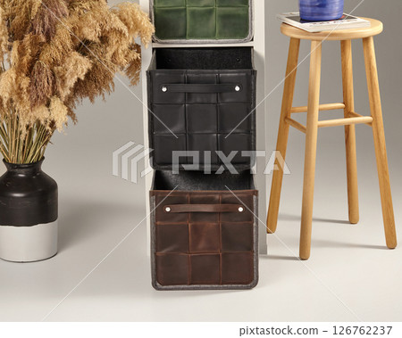 Stylish leather storage boxes with wooden stool and pampas grass decoration 126762237