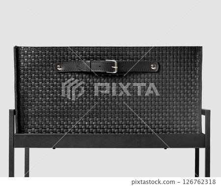 Black leather chair back showing weaving and belt detail on modern furniture Black leather chair back showing weaving and belt detail on modern furniture 126762318
