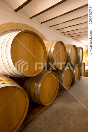 wine wooden oak barrels stacked in a row at winery wine wooden oak barrels stacked in a row at winery 126762784