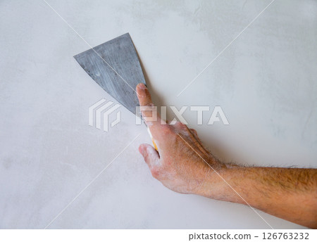 Plastering wall with plaste and plaster spatula trowel 126763232