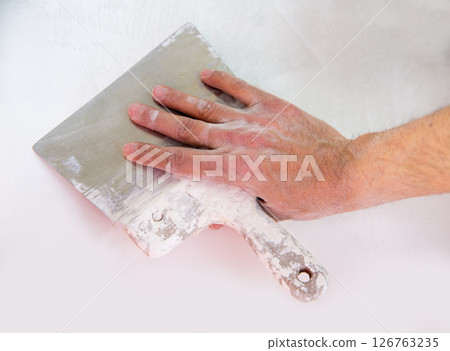 Plastering wall with plaste and plaster spatula trowel 126763235