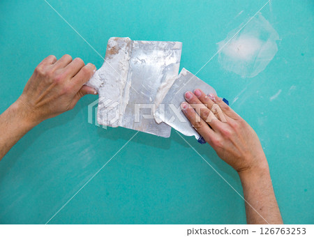 Plastering man hands with plaste on drywall plasterboard Plastering man hands with plaste on drywall plasterboard 126763253