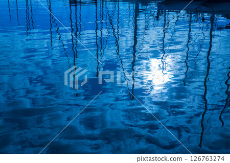 Blue water reflection of sailboats boats poles in waves Blue water reflection of sailboats boats poles in waves 126763274