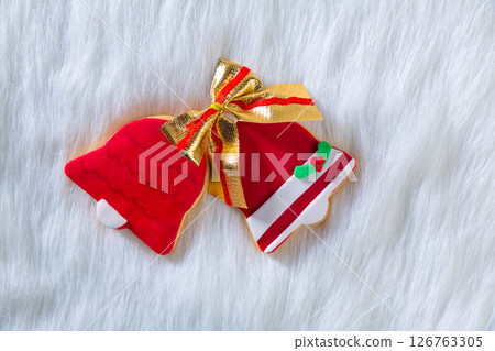 Christmas cookies red bell shape and ribbon on white fur 126763305